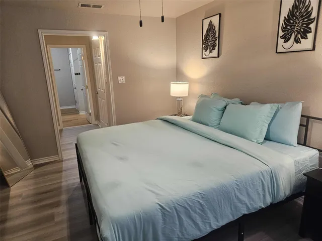 a bedroom with a bed and painting on the wall