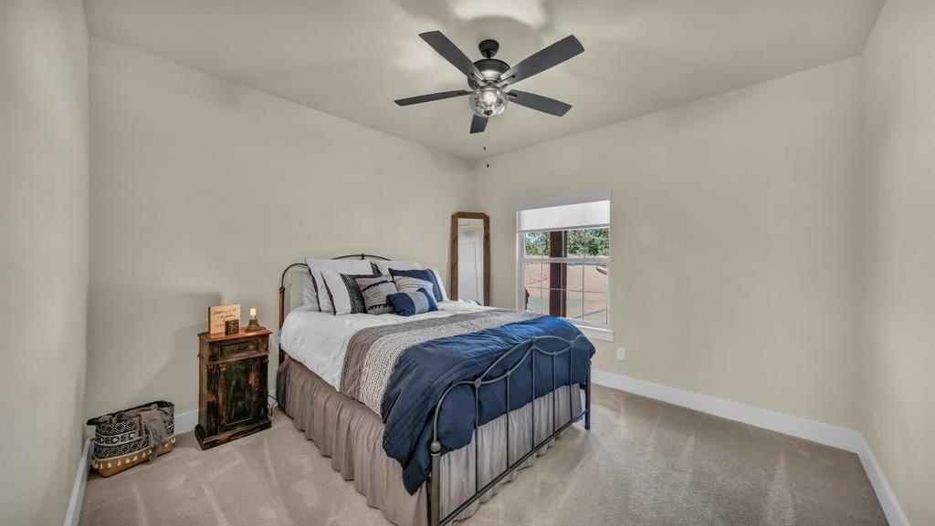 1320 Post Oak Road Gordon, TX 76453 - Photo 25 of 40 a spacious bedroom with a bed and a ceiling fan