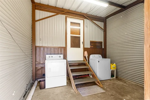 a backyard of a house with large trees and a barn