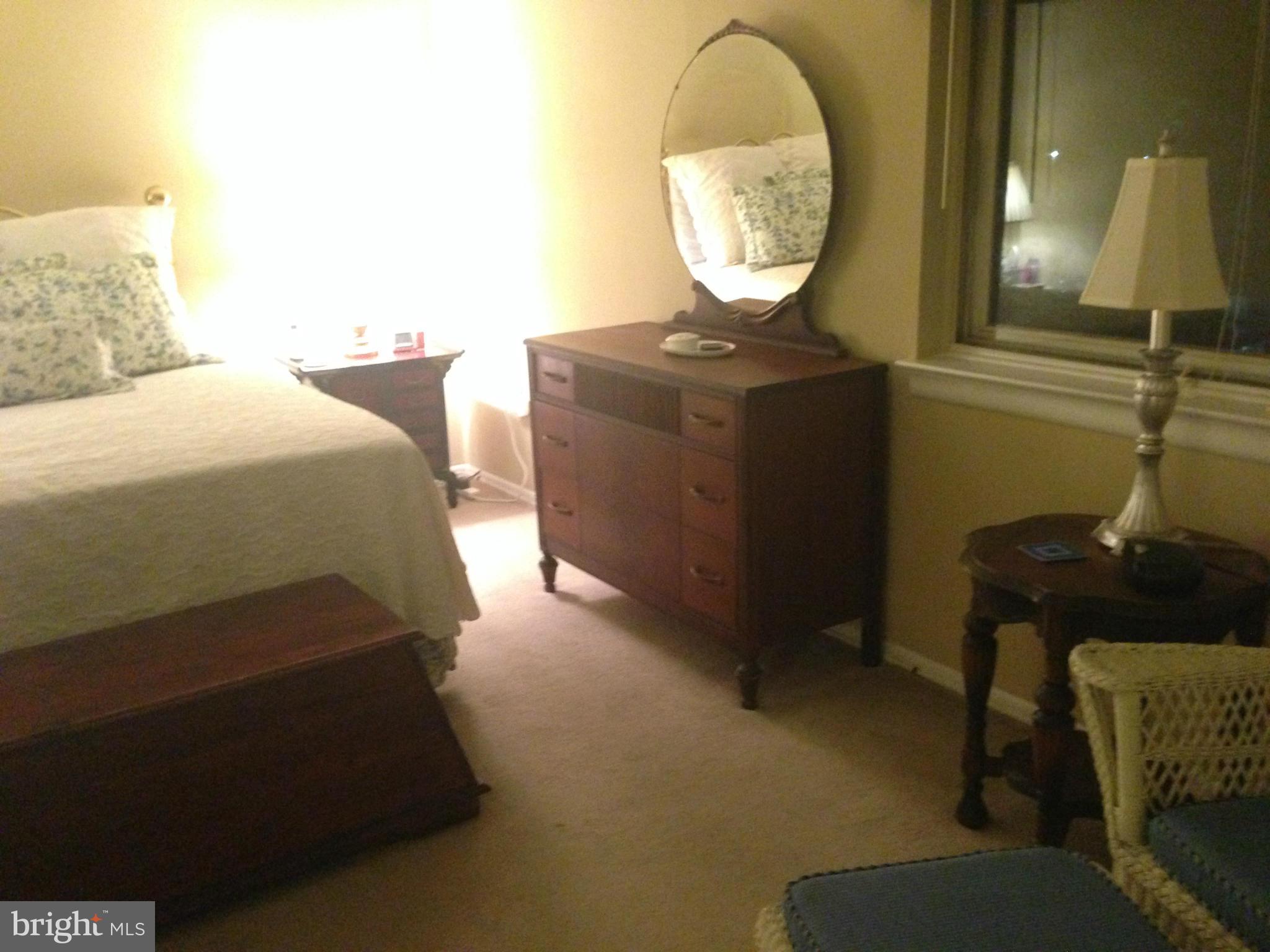 11368 Cherry Hill Road, Unit 304 Beltsville, MD 20705 - Photo 2 of 11 a bedroom with a bed and a mirror