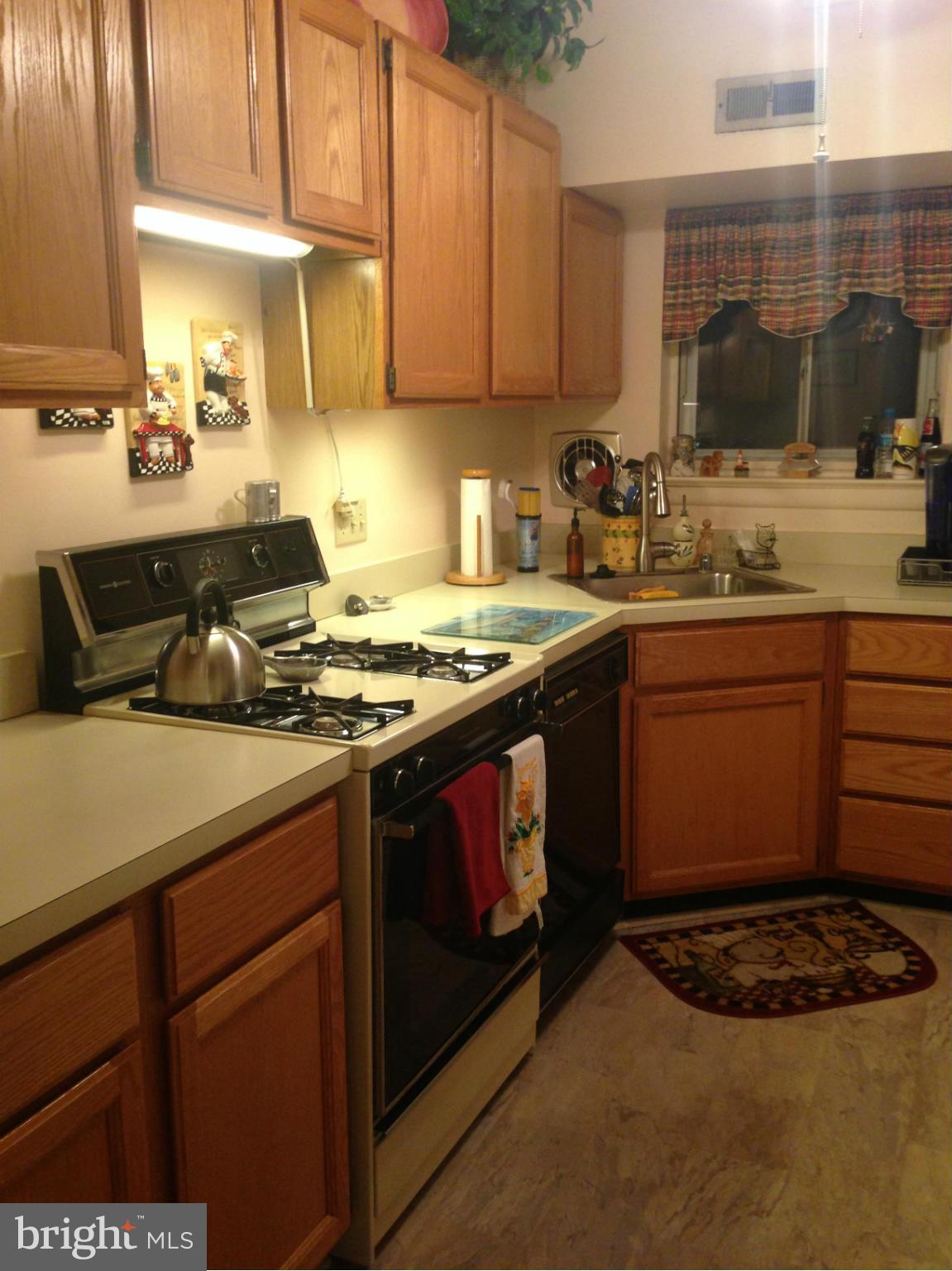11368 Cherry Hill Road, Unit 304 Beltsville, MD 20705 - Photo 8 of 11 a kitchen with a sink stove and cabinets
