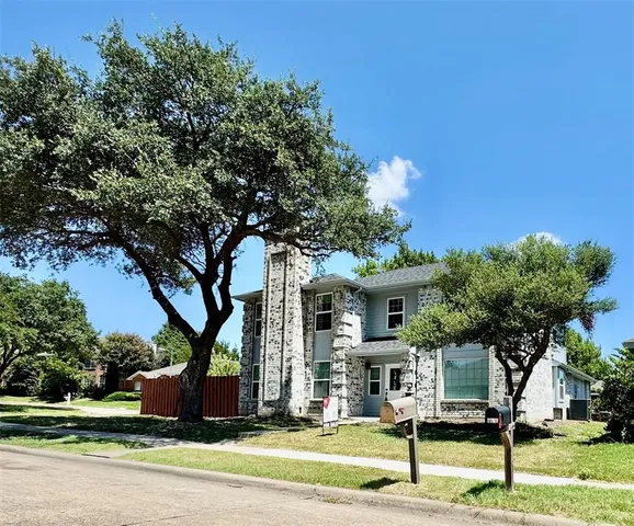 a view of an house with backyard and trees
