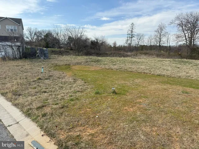 a view of a yard with wooden fence
