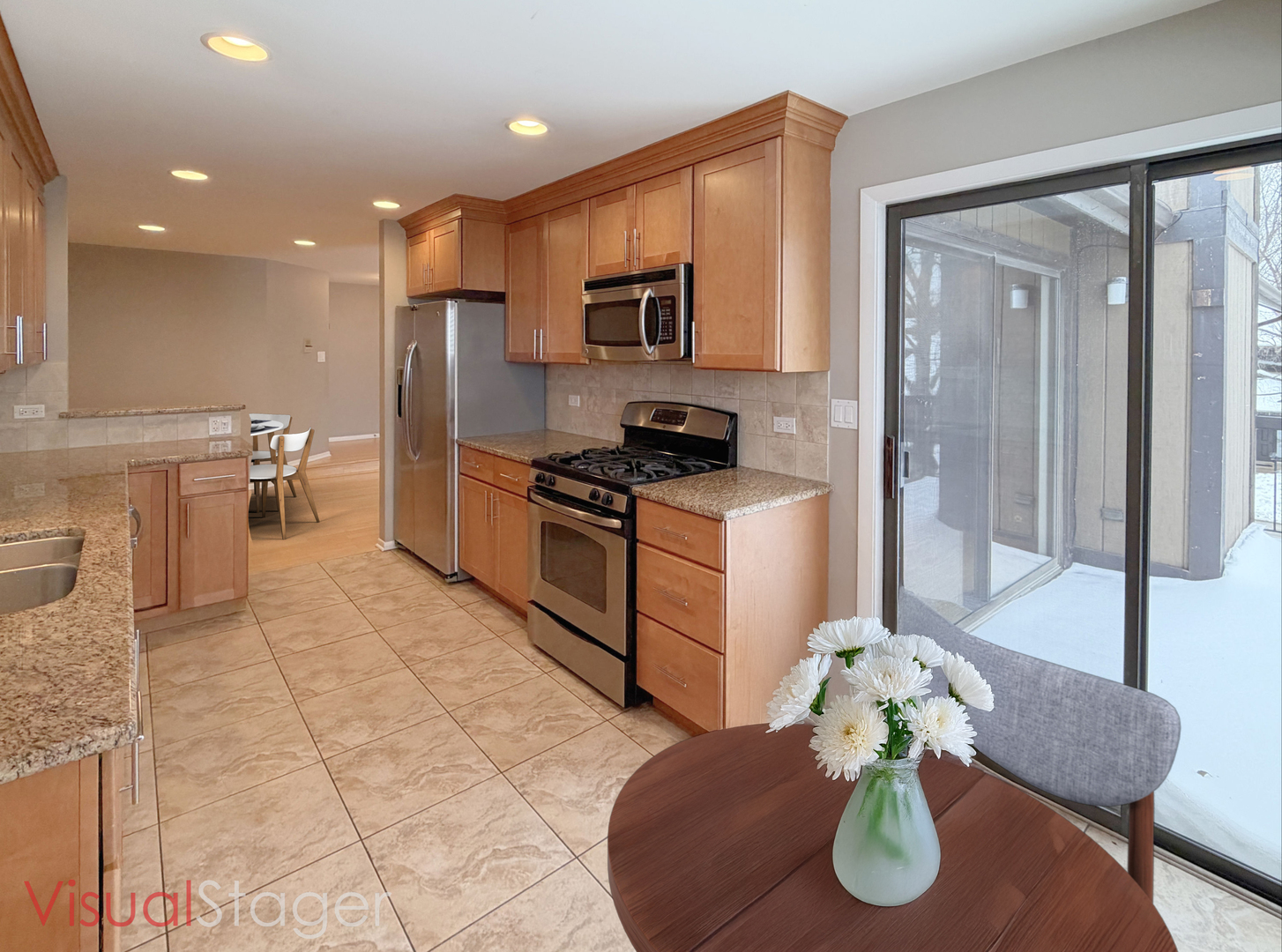 22 Creekside Circle, Unit D Elgin, IL 60123 - Photo 9 of 23 a kitchen with stainless steel appliances granite countertop a sink a stove a microwave a dining table and chairs