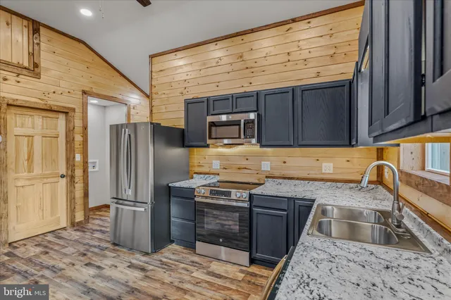 a kitchen with stainless steel appliances granite countertop a refrigerator stove and sink