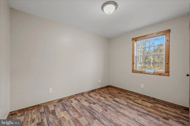 a view of a room with wooden floor and a window