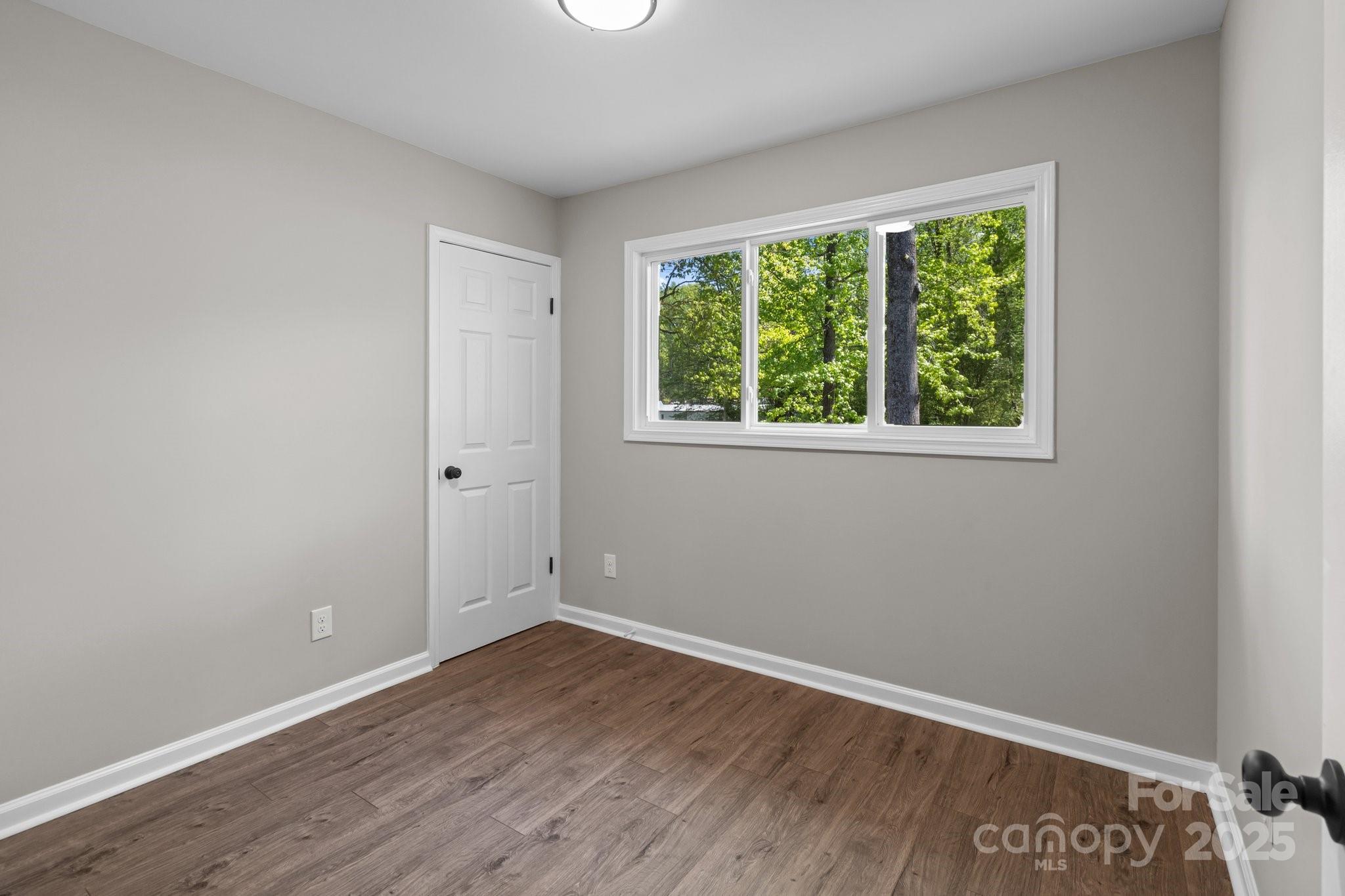880 Legion Club Road Salisbury, NC 28146 - Photo 13 of 35 an empty room with wooden floor and a window