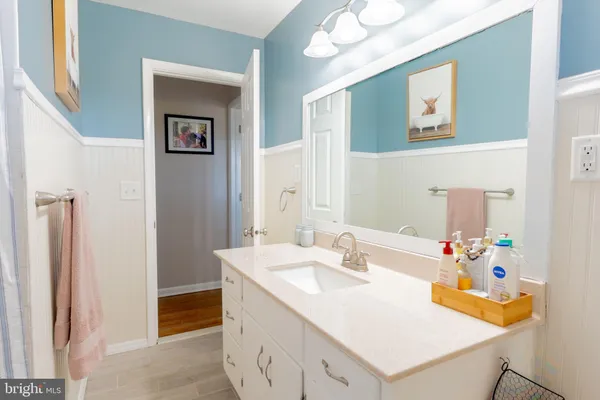a bathroom with a sink vanity and a mirror