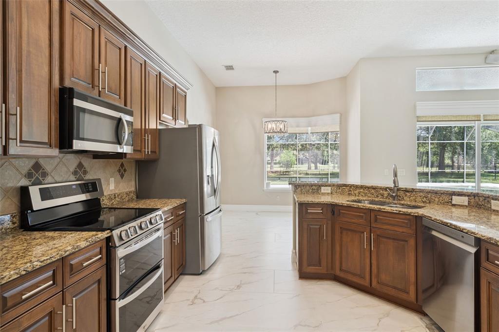 2230 Ridgewind Way Windermere, FL 34786 - Photo 14 of 38 a kitchen with stainless steel appliances granite countertop a stove a sink dishwasher a refrigerator and a microwave