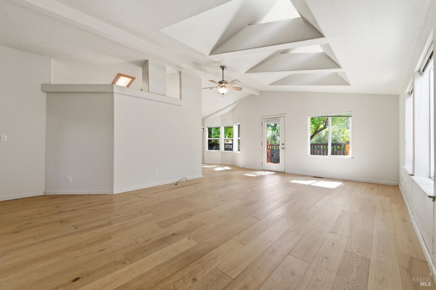 2412 Foothill Boulevard, Unit 15 Calistoga, CA 94515 - Photo 2 of 16 an empty room with wooden floor windows and a ceiling fan