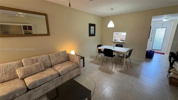 a living room with furniture a wooden floor and a mirror