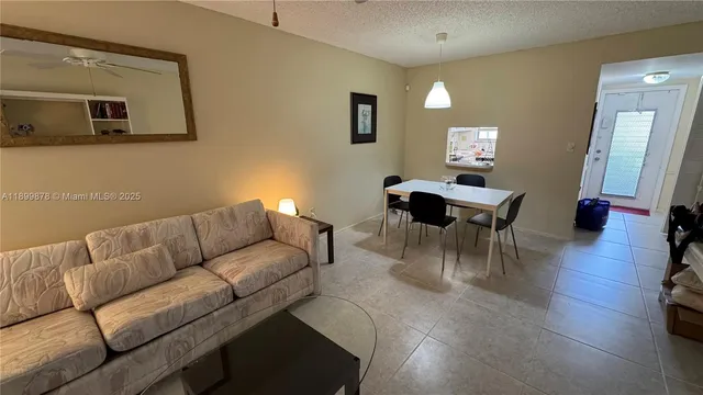 a living room with furniture a wooden floor and a mirror