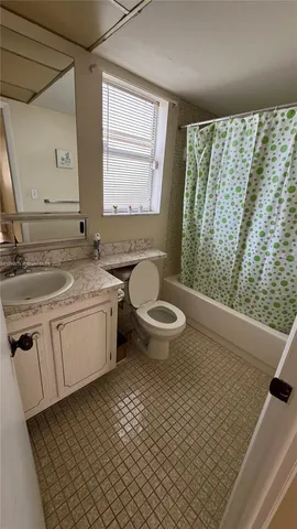 a bathroom with a granite countertop sink toilet and mirror