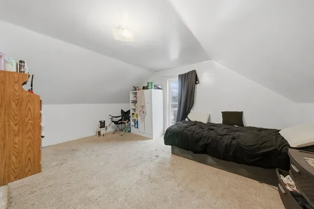 a bedroom with a bed and a large mirror