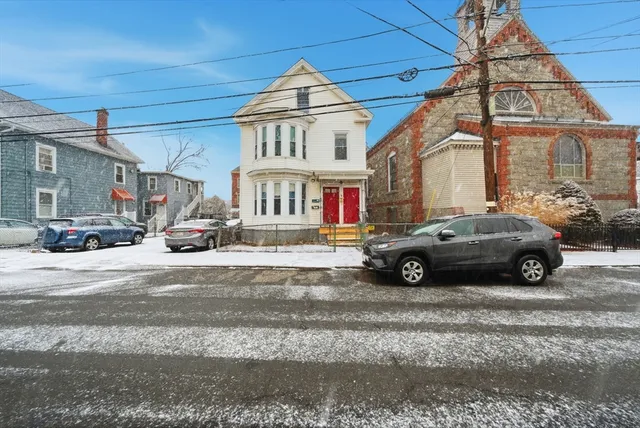 a car parked in front of a white house