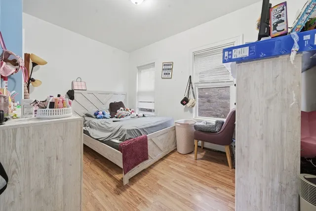 a living room with stainless steel appliances kitchen island granite countertop a sink and a wooden floor