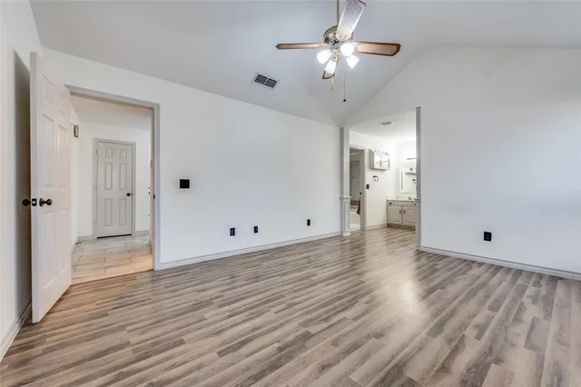 a view of a livingroom with wooden floor and a ceiling fan