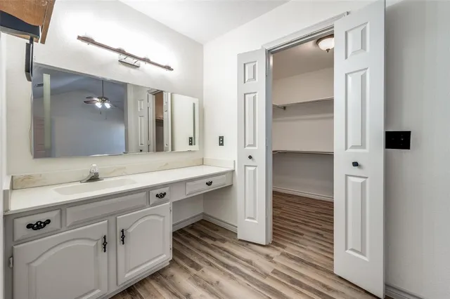 a spacious bathroom with a shower a sink and a mirror