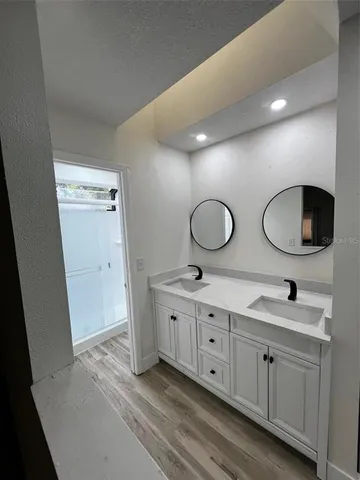 a bathroom with double vanity sink a mirror a vanity and window