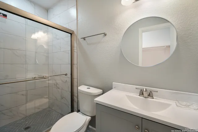 a bathroom with a sink toilet and a mirror