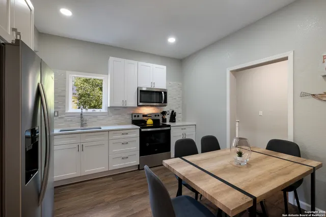 a kitchen with a table chairs refrigerator and microwave