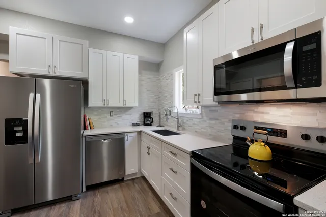 a kitchen with a sink stainless steel appliances and cabinets