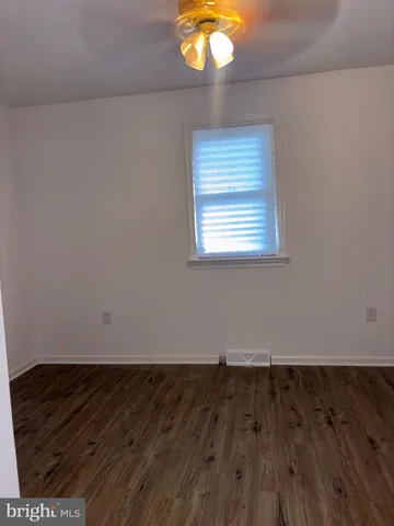 a view of a room with wooden floor and fan