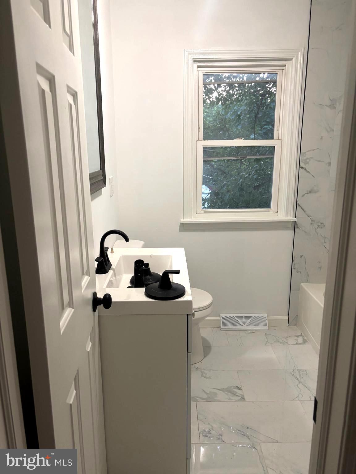 4216 West 7th Street Trainer, PA 19061 - Photo 16 of 26 a bathroom with a sink a window and a toilet