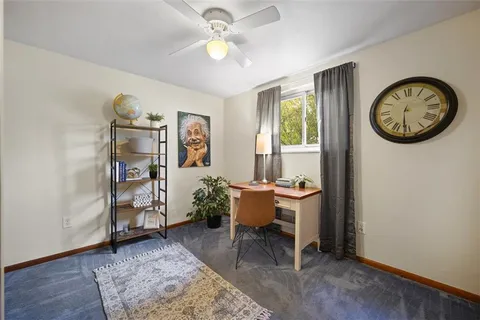 a view of a workspace with furniture and a window