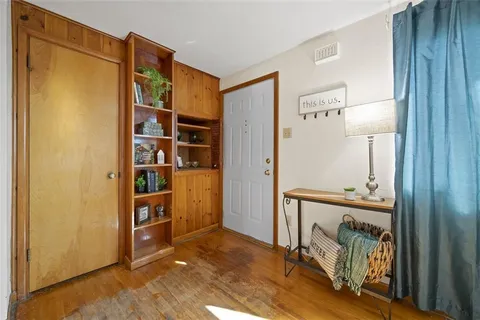 a view of a hallway with wooden floor and windows