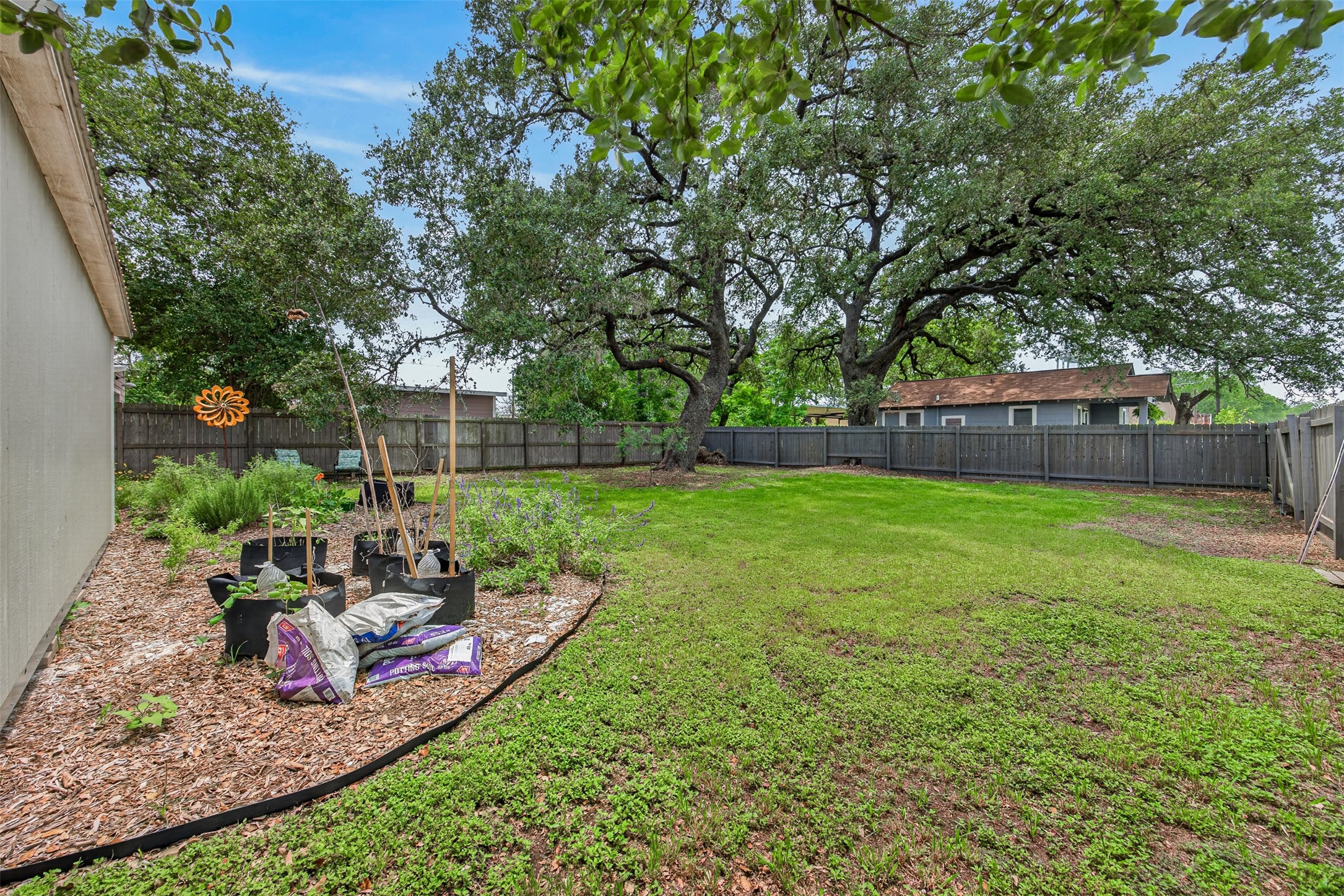 217 Walnut Avenue Luling, TX 78648 - Photo 31 of 38 a view of a backyard with table and chairs potted plants and large tree