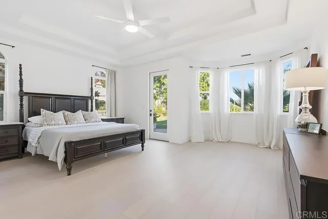 a bedroom with a large bed and a flat tv screen