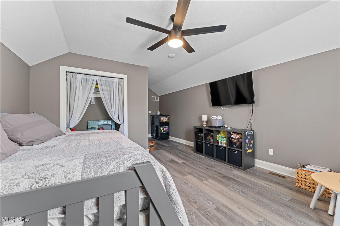 3048 Wright Road Northwest Uniontown, OH 44685 - Photo 23 of 30 Bedroom with light wood-style flooring, vaulted ceiling, and ceiling fan