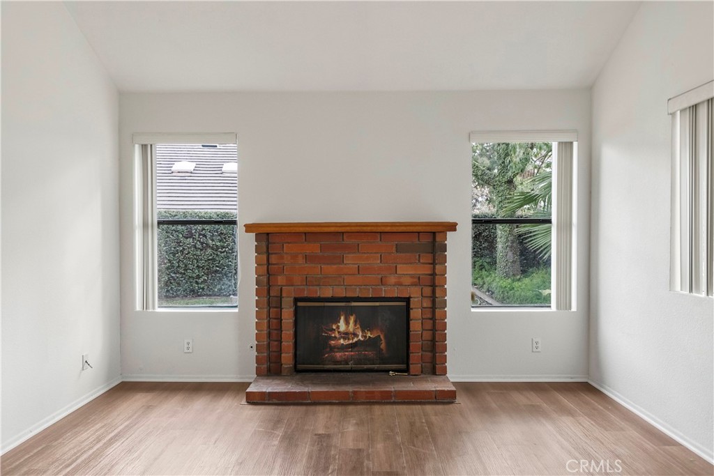 2176 Glenview Terrace Riverside, CA 92506 - Photo 8 of 36 an empty room with wooden floor fireplace and windows