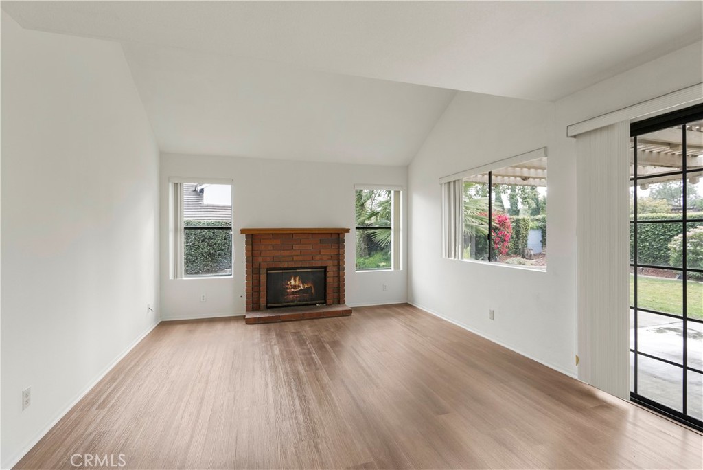 2176 Glenview Terrace Riverside, CA 92506 - Photo 9 of 36 an empty room with windows a fireplace and wooden floor