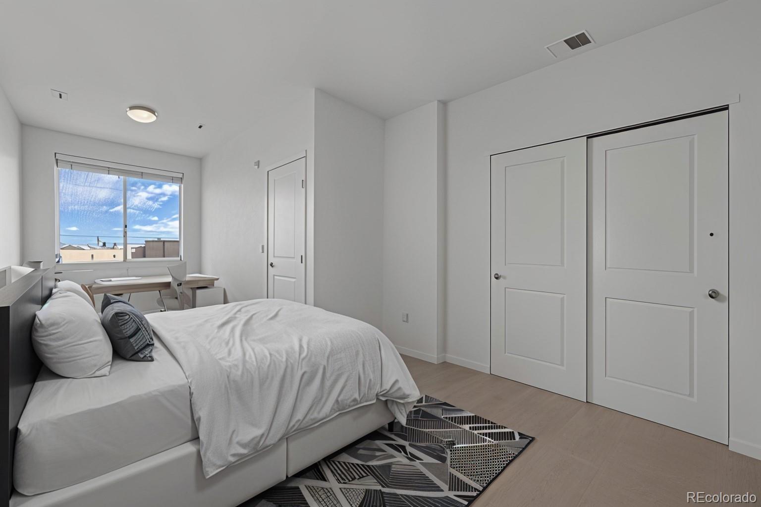 4100 Albion Street, Unit 320 Denver, CO 80216 - Photo 23 of 45 a bedroom with a bed and a window