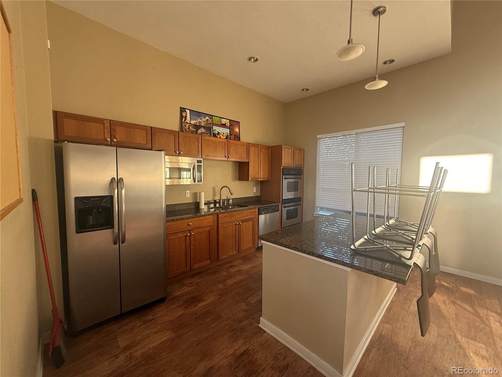 4100 Albion Street, Unit 320 Denver, CO 80216 - Photo 41 of 45 a kitchen with stainless steel appliances granite countertop a sink and a refrigerator