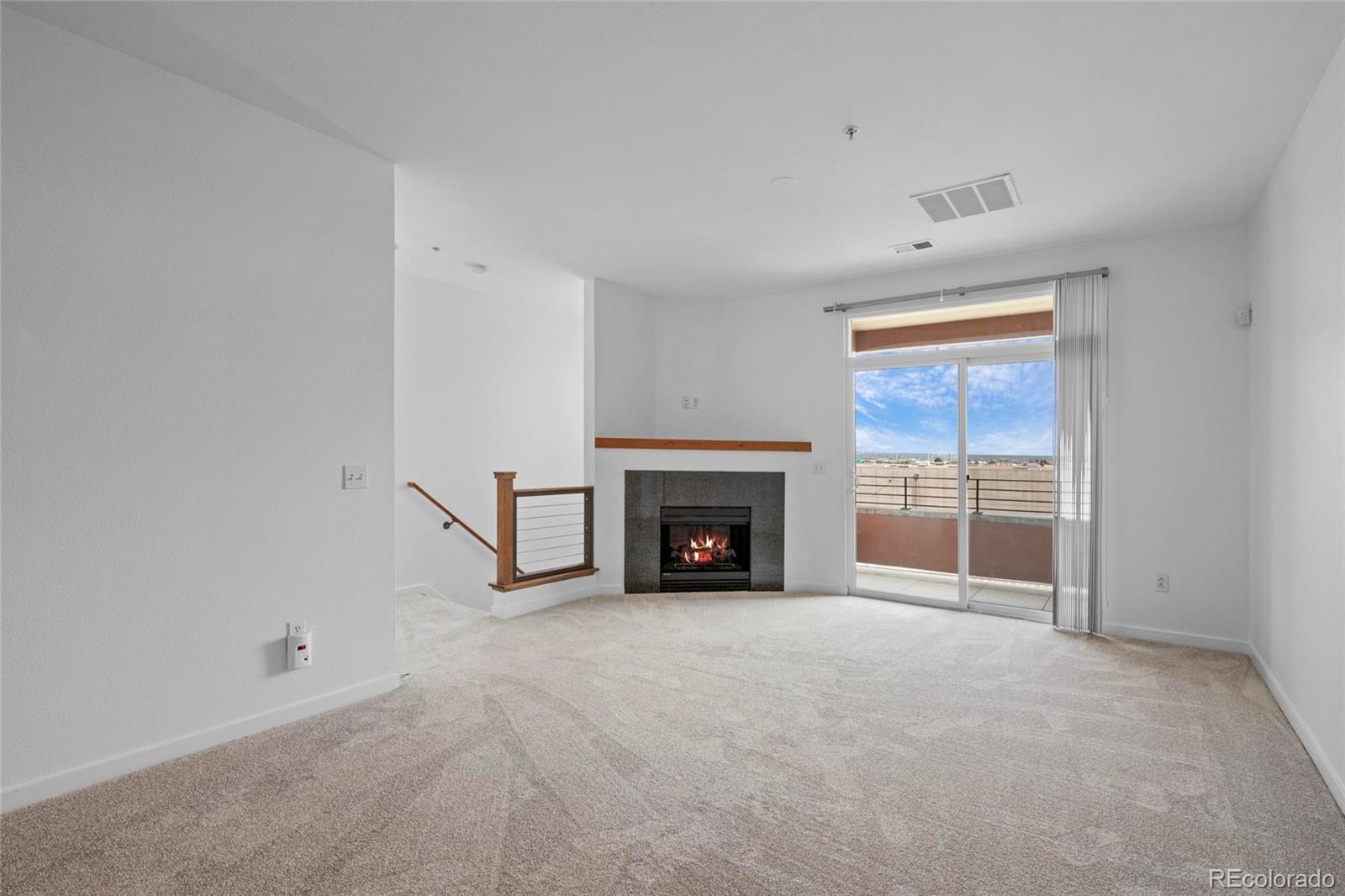 4100 Albion Street, Unit 320 Denver, CO 80216 - Photo 9 of 45 a view of an empty room with a fireplace and a window