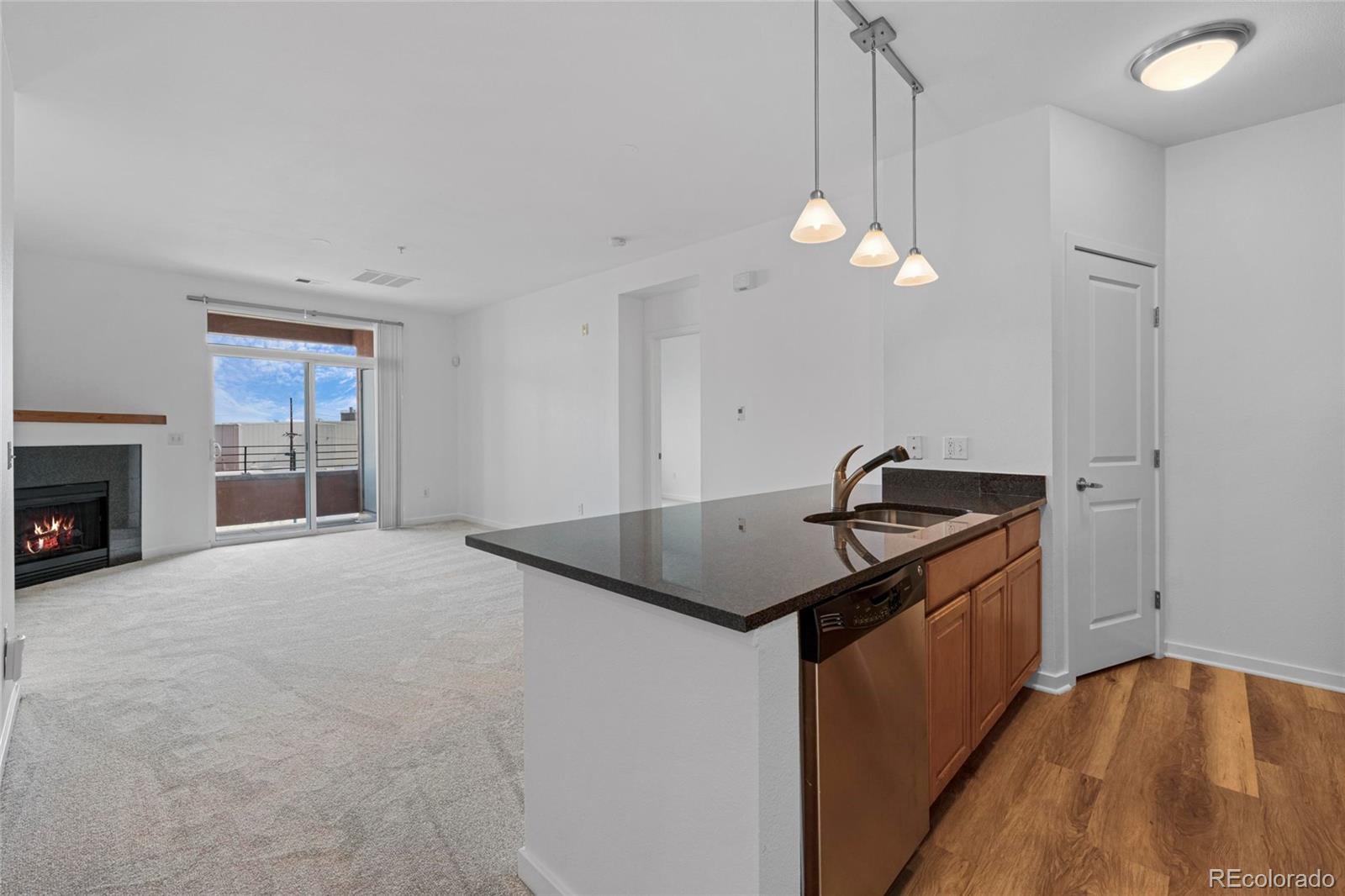 4100 Albion Street, Unit 320 Denver, CO 80216 - Photo 10 of 45 a kitchen with granite countertop a stove a sink and a chandelier