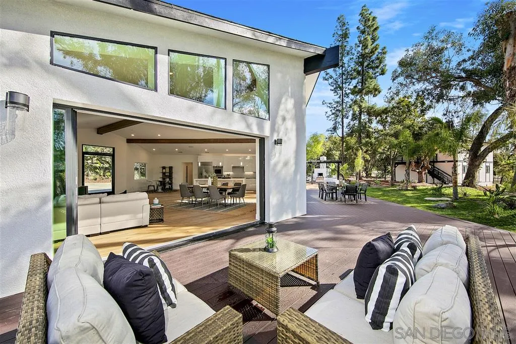 a view of a patio with couches table and chairs and potted plants