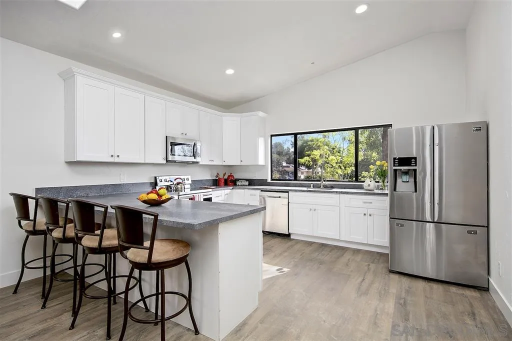 17502 Rancho Del Rio Rancho Santa Fe, CA 92067 - Photo 15 of 20 a kitchen with stainless steel appliances a white stove top oven and a refrigerator