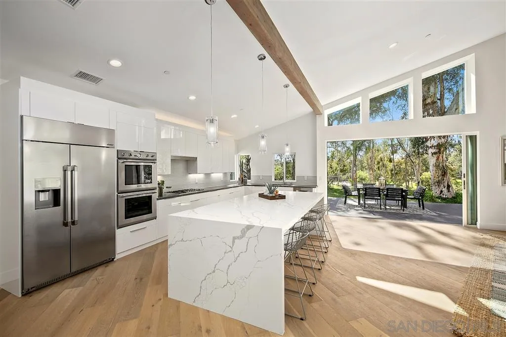 17502 Rancho Del Rio Rancho Santa Fe, CA 92067 - Photo 5 of 20 a large kitchen with stainless steel appliances kitchen island a large counter top and a refrigerator