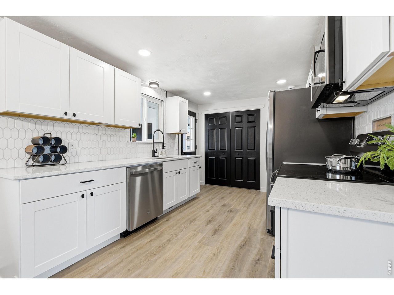1239 Sunset Street Longmont, CO 80501 - Photo 11 of 34 a kitchen with stainless steel appliances kitchen island granite countertop a refrigerator oven a sink dishwasher and white cabinets with wooden floor