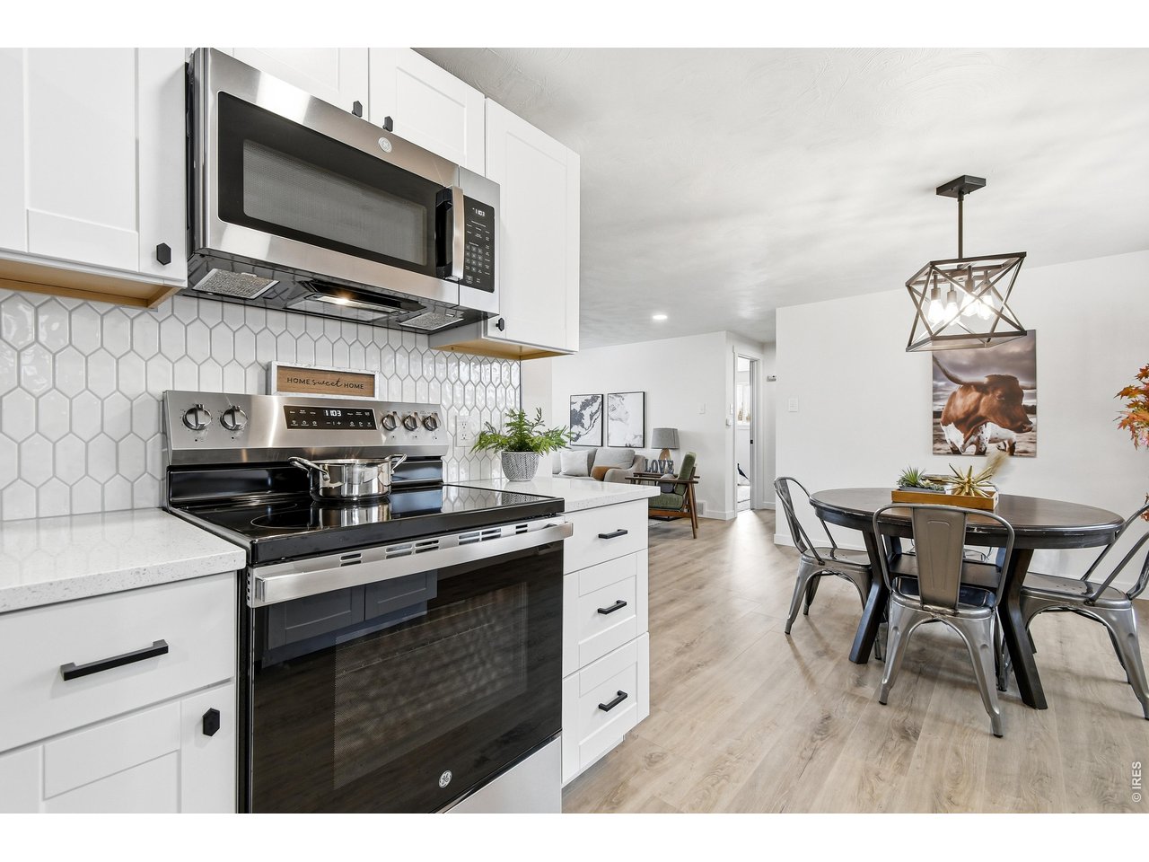 1239 Sunset Street Longmont, CO 80501 - Photo 14 of 34 a kitchen with stainless steel appliances granite countertop a stove top oven a sink dishwasher a dining table and chairs with wooden floor