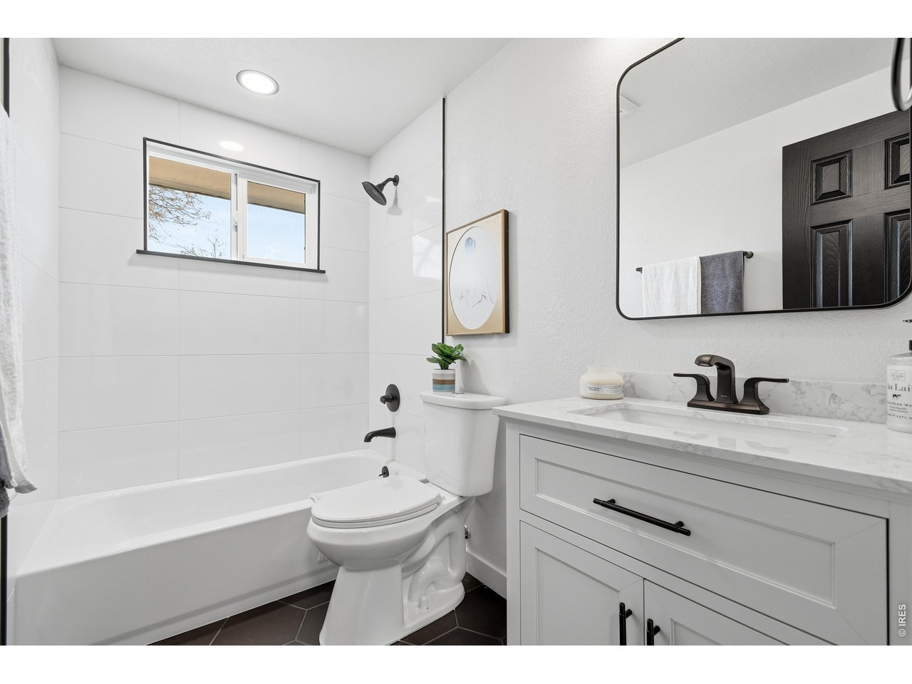 1239 Sunset Street Longmont, CO 80501 - Photo 25 of 34 a bathroom with a bathtub sink vanity mirror and toilet