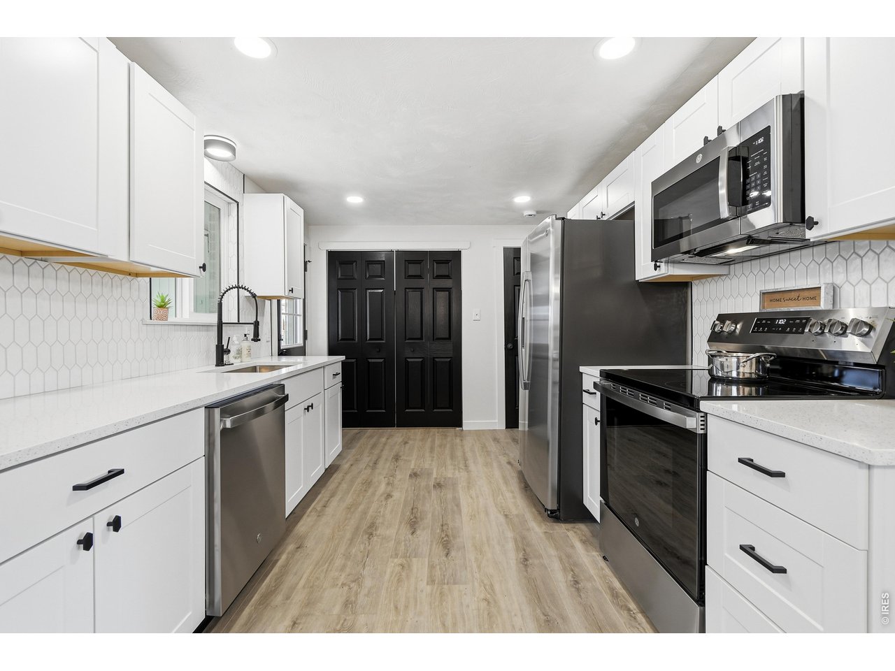 1239 Sunset Street Longmont, CO 80501 - Photo 10 of 34 a kitchen with stainless steel appliances granite countertop a refrigerator a stove top oven a sink dishwasher and wooden cabinets