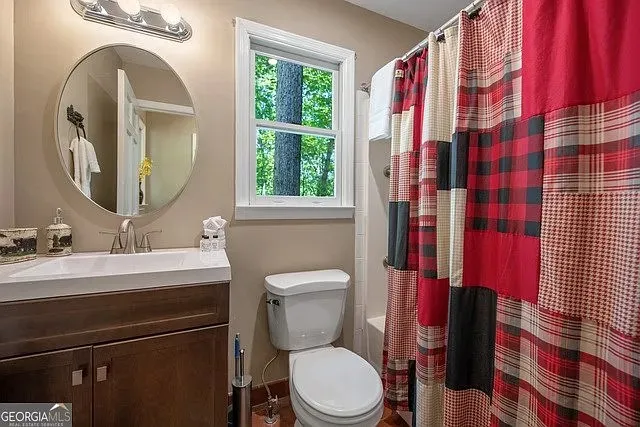 a bathroom with a toilet sink vanity and mirror