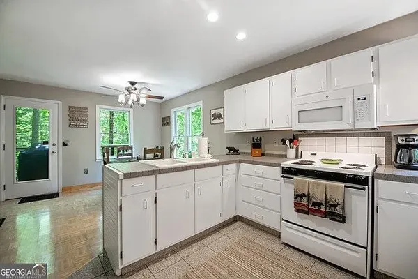 a kitchen with stainless steel appliances granite countertop a stove and white cabinets