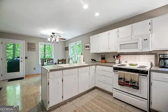 a kitchen with stainless steel appliances granite countertop a stove and white cabinets