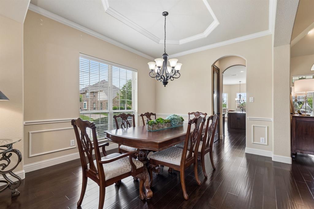 2701 Brunswick Cove Trophy Club, TX 76262 - Photo 11 of 40 a dining room with furniture wooden floor a rug a potted plant and a chandelier